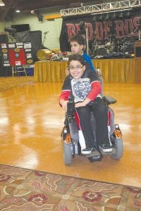 While waiting for the spaghetti dinner, Easter Seals Ambassador Zachary Pylychuk, 8, of Thunder Bay, gave his little brother Nathaniel a ride on the back of his motorized wheelchair.