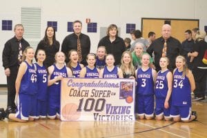 When Head Coach T.J. Super recorded his 100th win against the Duluth Marshall Hilltoppers at home on February 9, his team was ready with big smiles and a sign that says it all. (L-R, front) Lily Gruber-Schulz, Ashley Deschampe, Bekah Laky, Theresa Morrin, Breana Peterson, Shelby Sjogren, Leah Utities, Molly Zaft, Kaitlyn Linnell, Jessica Berg-Collman, Deedra Mongen, Jordan Deschampe. (L-R, back) Kim Linnell, Rachel Seim, T.J. Super, Kelly Roberts and John Jacobsen. Right: Going up, up and away for two points against the Marshall Hilltoppers was the Vikings' outstanding young center Lily Gruber-Schulz.