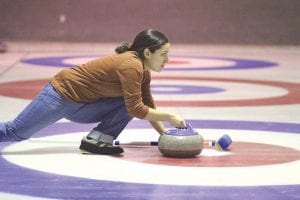 Above: Taking dead aim just before she let her rock go, Monica Webster played for the winning B event team which included Steve Hudler, Bill Parish and Marshall Pedersen. Right: Two studious curlers from Canada work fast and furiously with their brooms.