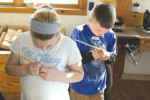 Jacob Paisley School third graders Smith and Sawtooth Elementary Smith busily work on their Paddle- to- the- Sea carvings at North House Folk School on March 14.