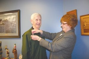 Taking a stand. Jodi Yuhasey of the Violence Prevention Center pins a white ribbon on Bob Carter’s shirt. Carter agreed to wear the ribbon and be part of the White Ribbon Campaign, which asks everyone to take a stand against violence. During the month of April, Cook County residents are asked to wear a white pin as a pledge to “never commit, condone or remain silent about violence against another person.”