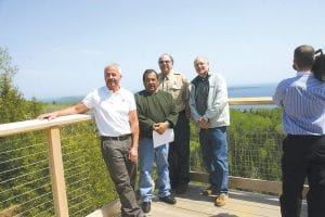 Enjoying the view—and enjoying the results of their collaboration—representatives of the groups that worked to develop and fund the new Mount Josephine Wayside Rest visited on the viewing deck after the ribbon cutting on Friday, May 18. (L-R) Rob Wells of MN/DOT, Grand Portage Tribal Chair Norman Deschampe, Rick Novitsky of Grand Portage State Park and County Commissioner Bruce Martinson, a member of the North Shore Scenic Drive Council.