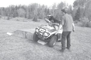 Steve Lashinski of Steve’s Sports, a DNR certified ATV safety instructor, watches a young rider practice riding on a slanted ramp, part of the DNR ATV safety course. Recent DNR statistics show a decline in youth-involved incidents, largely due to safety training requirements for those ages 15 and under. Adults who have not completed safety training are now the most at risk. The DNR reminds all ATVers to keep safety in mind.