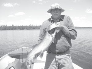 Larry Waalkens shows off the beautiful 18-pound lake trout he caught on Lake Saganaga. With him was Master Guide Ron Vance. Both men are summer residents of the Grand Marais Municipal Campground.