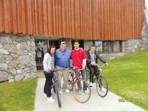 Some of last year’s Workers on Wheels participants picking up bicycles from volunteer Dan Strayer.