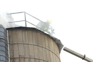 Firefighters Kyle Oberg and Aaron Mielke climbed to the top of the 40-foot silo at Hedstrom Lumber Company to douse the fire inside. The flames were extinguished quickly, but the wood byproducts inside continued to smolder for a couple of hours. Hedstrom Lumber Company Vice-president Jack Hedstrom said the silo was not damaged by the fire or water used to extinguish it.