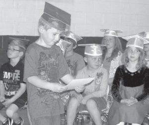 Arlo, graduating from kindergarten to first grade, checks out his certificate.