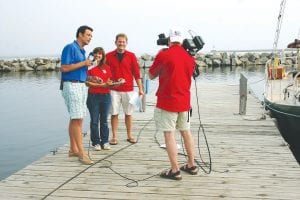 Anchor Frank Vascellaro (left) and Head Meteorologist Chris Shaffer of WCCO/ Channel 4 TV in the Twin Cities interview Dee Brazell of World’s Best Donuts at the Grand Marais Marina on May 18. They were conducting a live broadcast as part of a five-day tour of lake areas in Minnesota and Wisconsin. Fog and sunshine played tug-of-war during the broadcast, giving them an accurate picture of June on Lake Superior.