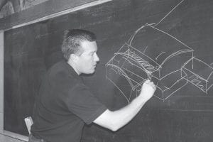 The blackboard in the former School District 166 classroom— now the Mianowski Conference Room—came in handy after the latest meeting of the Cook County Steering Committee on Friday, June 22. Architect Dan Miller of JLG Architects talked to steering committee members about building design and sketched some concepts while he listened.