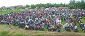 Top: The field in front of the AmericInn in Silver Bay was full of ATVs in the Saturday, June 23 attempt to reclaim the Guinness Book of World Records entry for “World’s Longest ATV Parade.” There were 1,060 ATVs, along with a hundred or more side-by-side machines, which do not count according to Guinness. Although disappointed that they did not regain the Longest ATV Parade title, ATV enthusiasts had a great time. Lower left: ATVers young and old, with American flags, and other adornments took off, row by row in the parade. Lower right: Members of the Cook County ATV Club sported yellow whip safety flags with the club logo.