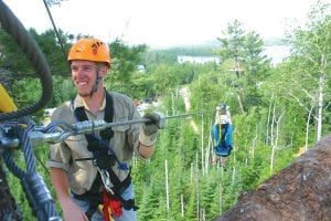 Next? After helping send Megan Powell off on the zip line to the next towering pine, Sky Guide Keith Gortowski turns to help another adventurous guest. The Sky Guides are ever-mindful of safety, ensuring that Towering Pines Canopy Tour participants are connected to the platform or the massive pines at all times.