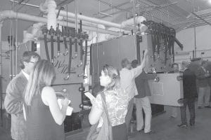 Above: Two biomass boilers have been installed at Wolf Ridge Environmental Learning Center in Finland, Minnesota. Some see biomass as an excellent source of energy for northern Minnesota, with new technologies creating efficient and environmentally friendly systems. Right: (L-R) At the festivities celebrating the new system were Mike Garey of Hovland, on the Cook County Local Energy Project Biomass Work Group, and Craig Engewall, Minnesota Department of Natural Resources regional manager.