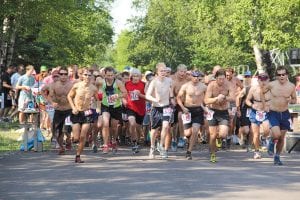 Wearing bib number 141, Adam Swank of Duluth (who would win the race) checks his watch as the race leaves the Birch Grove Community Center parking lot. There was a lot of joy at the start and a lot of relief at the finish.