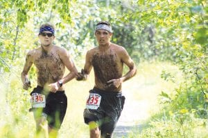 Above: There wasn’t a lot of mud on the trail this year, but Jeremy Dockan (left) and David Bergstrom found just enough to cover themselves from head to foot. Right: Local young runners Kieran Scannell and Drew Holmen had the most exciting race of the day. Scannell edged Holmen by two tenths of a second to finish second overall in an all out sprint to the finish line.