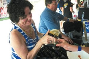 Madeline Fyten of the St. Croix Brewing Company pours a sample of her company’s dark amber beer for a customer.