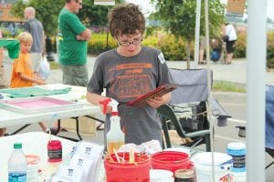 The Grand Marais Arts Festival on Saturday and Sunday, July 13 - 14 had lots of interesting demonstrations. Vaughn Swindlehurst of Grand Marais helped out in a booth that offered the opportunity to screenprint your own Grand Marais Art Colony T-shirt. Vaughn is sporting the T-shirt designed by his dad, Mike Swindlehurst. See more Art Colony activities on page A3.