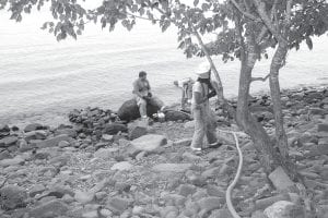 Grand Marais Fire Department members work to get a submersible pump going and hoses connected to extinguish a small fire on the Sweetheart’s Bluff Trail in Grand Marais.