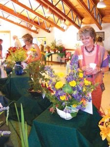 Above: The theme of this year’s West End Garden Club flower show on July 21 was “Superior Women.” As usual, the arrangements were extremely creative, giving tribute to women near and dear such as mothers, daughters, and sisters- and mothers-in-law; local legends such as Justine Kerfoot and Dorothy Molter; and famous women who have been inspiring, such as Sacajawea and Eleanor Roosevelt. Right: An arrangement on a Swedish theme by Judy Gregg in honor of Eileen Hall, using daisies, lilies, and bird’s foot trefoil.