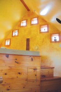 Above left: Natural light and warm color surround users of the soaking tub underneath these windows. Center: This home on Lake Superior is swathed in poplar bark that was cut into shingle-size sections and then flattened with steam. Right: This little cabin, built in 1940, is the epitome of a Northwoods cabin. It has a pinepaneled galley kitchen with a single sink/refrigerator/stove/oven unit, a sleeping loft, and a stone fireplace in the living room.