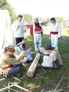 A visit to Grand Portage Rendezvous Days is a step into the past. Left: You can see voyageurs at work—these men are peeling a log with a lot of “helpful supervision” from friends at the encampment. Above: The Grand Portage Powwow offers wonderful ceremonial dance and drumming.