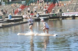 Left: With the whitewater flying Jessica Berg-Collman (left) runs Emily Burger of LaCrosse off the log for the third and final fall to win the semi-pro log rolling world championships at Hayward, Wis. Last weekend. Above: Lucy Shaw displays her U10 girl’s world championship plaque. Lucy is a repeat winner of the U10 division.