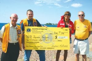 Jaymee Jackson was all smiles as Grand Marais Lions Club President Andrew Smith handed her the Fisherman’s Picnic grand prize check for $10,000. Standing beside Jaymee is her father, Stuart Jackson. On Andrew’s left is Lion Bob Spry. Although Jaymee now lives in Stillwater, Minnesota, she and several of her Cook County High School classmates from the Class of 1978 come and work in the Lions' fish burger stand with Stuart and many other Lions and Lionesses.