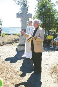 Bishop Paul Sirba of the Duluth Catholic Diocese and Father Seamus Walsh of St. John’s Catholic Church in Grand Marais stand before Father Baraga’s Cross at a rededication ceremony August 5, 2012. The cross was erected 80 years ago and was recently moved several yards so it would stand on Catholic Church property adjacent to the Schroeder Township park. A wooden cross was placed on the site in 1846 as a symbol of thankfulness after Father Baraga and an Indian guide barely made it through a storm on Lake Superior as they paddled from the Apostle Islands to the North Shore.