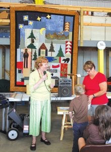 In addition to being a great fundraiser for the Gunflint Trail Volunteer Fire Department, the MidTrail event was a lot of fun. Far left: Linda Henricksson, president of the Mid-Trail Property Owners Association with Nancy Ohmen and the young man who drew the winning ticket for the beautiful Northwoods quilt. Jo Ann Krause was the lucky quilt winner. Left: The auction included many interesting items. Harvey Perusse modeled a Russian hat that was donated for the auction.