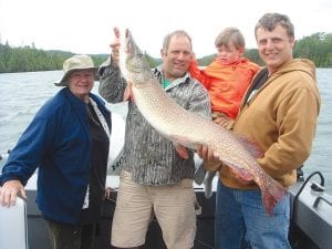 Above: The Atkinson family had a great weekend of fishing on Isle Royale August 11 -12. Niel Atkinson said it is a little-known secret that in addition to great lake trout fishing, there are giant northerns to be found at the island. The largest caught over the weekend was 44 inches and was reeled in by Niel’s mom Kathleen Atkinson. Niel’s nephew, Harmon Hanson also caught a nice 36-inch northern. (L-R) Kathleen Atkinson, Niel Atkinson, Berendt “Bear” Atkinson, Harmon Hanson with one of the monster northerns. The big fish was released. Right: Niel Atkinson (right) and his nephew Harmon Hanson of Missoula, Montana, along with other family members, caught northerns and some very nice lake trout on their Isle Royale fishing weekend August 11 -12. The family enjoyed some delicious trout dinners.