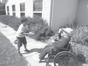 North Shore Care Center Activities Director Kay Rosenthal said care center residents greatly enjoyed having student volunteers at the Care Center over the summer. One of the volunteers in the Incredible Exchange volunteer program was Isak Terrill, pictured here playing a water balloon toss game with Eleanor Matsis.