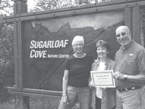 Andrea Peterson of Grand Marais accepts the Tombolo Award from board members of Sugarloaf: The North Shore Stewardship Association. Margit Berg and Greg Koschinska. The Tombolo Award is given yearly by the association to honor someone who has done much to preserve and restore the North Shore as a cultural gem.