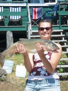 Left: Kristi Silence of Grand Marais shows off the very nice lake trout she caught while fishing near Isle Royale aboard the Fishing Buddy. The trout weighed 8 pounds.