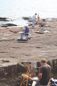 There were artists throughout the county during Plein Air Grand Marais, but on Thursday, September 13, they were concentrated on the Grand Marais harbor, taking part in the Quick Paint competition. Artists amicably found their spots for the competition and quietly got to work. These three are Neil Sherman in the foreground, David Hahn, middle and Tom McGregor nearest the water.