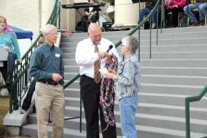 Left: Violence Prevention Center board member Judy Siegle presents to Judge Mike Cuzzo a Peace Fibres scarf created earlier that day by a group of community members to promote the cause of peace. It was made with 100 strands of fibre in honor of the courthouse’s anniversary. Above: Cook County Historical Center Museum Director Carrie McHugh and Grand Marais Lion Gene Erickson, a former county commissioner, reflect on Cook County history.