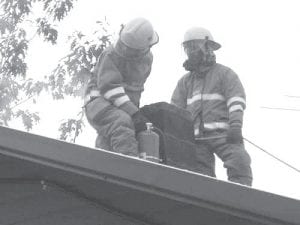 The firefighters of the Gunflint Trail Fire Department, like these two putting out a chimney fire, will see improvements to their fire halls this fall.