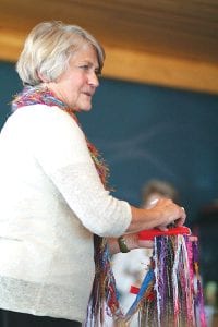 Above left: Karen Lohn, author of Peace Fibres: Stitching a Soulful World and resident of Grand Marais, led a gathering at East Bay Suites on September 21, 2012 in which small groups of community members created multi-strand scarves in the name of peace. She quoted Eleanor Roosevelt, who said, “It isn’t enough to talk about peace, one must believe it. And it isn’t enough to believe in it, one must work for it.” Many colorful baskets of yarn and fiber had been donated for this event. The scarves will be sent to leaders around the world with statements of encouragement for peace written by participants. “Peace. How do we find peace, personally and politically?” Lohn says. “Peace requires respectful relationship...to self...to one another...to Earth and all her creatures...to the larger whole. What if simple fibres offer a very real avenue toward this peace?...Fibre work connects us across time, across space, within.” Above right: Jane Howard helps sort groups of fibre strands.