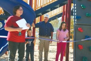 Birch Grove Foundation Director Patty Nordahl was all smiles as she introduced ribbon cutters Jack Laboda and Katrina Burkett (with helper Skip Lamb between them) at the unveiling of the newly installed playground equipment at the Birch Grove Community Center/School on Saturday, September 29. Jack and Katrina not only cut the ribbon, they also then played on the equipment with about 20-30 other children throughout the afternoon.