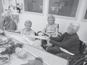 North Shore Care Center residents have been enjoying fall leaf tours and fall crafts, including work with fibers for the local International Day of Peace project. Elders at North Shore Care Center tearing cotton strips to braid together for the Scarves of Peace Project - used on International Peace Day September 21, 2012. (L-R) Dorothe Vaughn, Joyce Kehoe and Eleanor Matsis working, Phyllis Anderson watching.