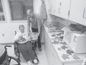 Fall crafts are a popular activity at North Shore Care Center. Joyce Kehoe and Belinda Hudler display leaves dipped in paraffin wax, which make great decorations.