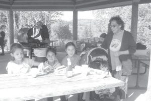 Grand Portage Elders have been getting out as much as possible before cold weather hits. On Grandparent’s Day, Sunday, September 9, Elders and kids gathered for a cookout at Grand Portage State Park. Pictured here is Marie Morrin and her grandkids. Arvid Dahl is watching the grill in the background.