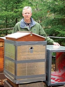 Local beekeeper Mark Ditmanson stands behind his honeybee hives, which he has insulated for the winter. After an infestation of mites was discovered in hives in Thunder Bay, Cook County became the last mite-free region in North America.