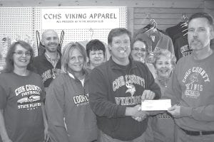 George Badeaux, pharmacist at Arrowhead Pharmacy in Grand Marais hands a check for $2,600 to Cook County High School Viking Booster Club president Jim Roy. The pharmacy sells Viking gear for the booster club. Proceeds of the sales supports CCHS athletic teams. (L-R) Val Groth, Nate Chandler, Terri Goettl, Paula Winters, Jim Roy, Jennifer Denewith, Ruth Tice and George Badeaux.