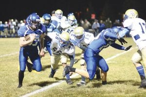 Above: Jacob Schroeder cleared a path for Viking running back Peter Warren in the game against Braham. Warren rushed for 195 yards in the game on 14 carries and Schroeder and the rest of the vaunted offensive line were named “Most Valuable Offensive Player(s) for the game” by the coaching staff for the great job they did in opening gigantic holes for the backs to run through. Right: All night long the Braham quarterback had to run for his life. Here he is being chased by No. 75 Justin Goldstein and Jonny Jacobsen.