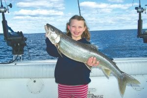 Katie Peck of Schroeder, 7, hefts a lovely 9-pound lake trout, one of the many lake trout she landed by herself while fishing with her dad, Captain Darren Peck aboard Tofte Charters on Sunday, September 23.