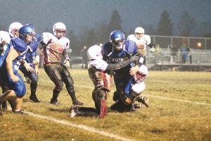 Upper left: In a rare moment, two Cass Lake-Bena players wrapped up Viking quarterback Kale Boomer for a fine tackle after Boomer had gained only 16 yards on the play. Above: Peter Warren broke for a long gain behind the blocking of Dakota Sorlie, Colin Everson and Thomas Anderson. Warren rushed for 8 touchdowns and had one called back. Left: Richie Furlong (reaching) and Owen Anderson combine on a fine tackle. The Vikings' varsity defense held the Panthers scoreless.