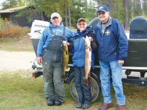 Left: Gail and Terry Englund enjoyed a fall fishing trip on Canadian Northern Light. The duo caught three “hog” walleyes—28, 28 ½ and a 29-inches, all released. The anglers also caught the 23- inch walleye and 34-inch northern pictured that they will use to make fishcakes. (L-R) Mike Berg of Seagull Creek Fish Camp, Gail Englund, Terry Englund.