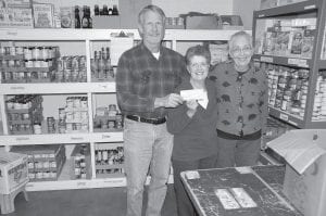 The Sons of American Legion Post 413 recently donated $1,000 to the Cook County Food Shelf, to help fill the void caused by increased needs in the fall and winter. Food Shelf volunteers were happy to pause from filling bags and boxes to accept the check. (L-R) American Legion Sons representative David Johnson, Food Shelf volunteers Gwen Lenz and Jean Perkins.