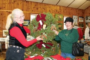 The Hovland Artisan’s Christmas Sale on Saturday, November 24 had amazing crafts, artwork and holiday goodies. Marcia Lacey (right) bought a lovely wreath crafted by Diane Pelto. The wreaths had wonderful touches of nature such as bits of lichen and pinecones.