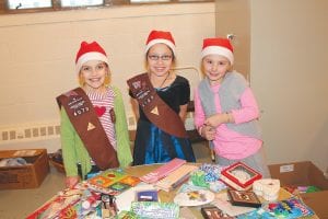 Santa’s Workshop, conducted by Cook County Girl Scouts, was a buzz of activity on Saturday, Dec. 1. These cheerful Brownies were ready to assist young shoppers find gifts for moms or dads. (L-R) Anna, Destiny and RaeAnne.