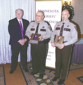 Above: Minnesota Sheriff Association President, Kandiyohi Sheriff Dan Hartog, presents the Medal of Valor to Cook County Sheriff Deputy Gary Radloff (center) on Dec. 3. When an officer receives the Medal of Valor, the sheriff’s office to which he is assigned also receives a plaque, which Cook County Sheriff Mark Falk is holding. Falk said the plaque is proudly displayed in the Law Enforcement Center lobby. Far left: Assistant County Attorney Molly Hicken received a Medal of Commendation, awarded to civilian personnel for acts of bravery. Left: Defense Attorney John Lillie was awarded the MSA Life Saving Award, for his actions to help save the life of Cook County Attorney Tim Scannell.